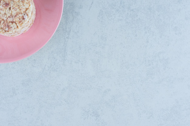 Воздушные рисовые лепешки и сладкий крекер в тарелке на мраморе.