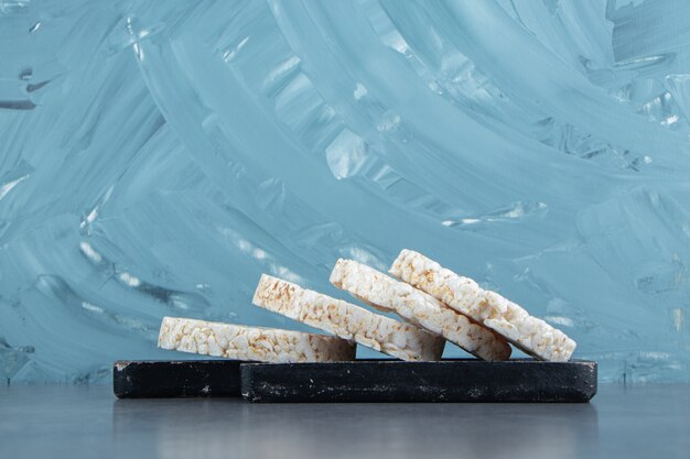 Puffed rice cakes on a wooden dark board.