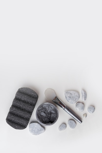 Pumice stone; spa stones; clay mask and brush isolated on white backdrop