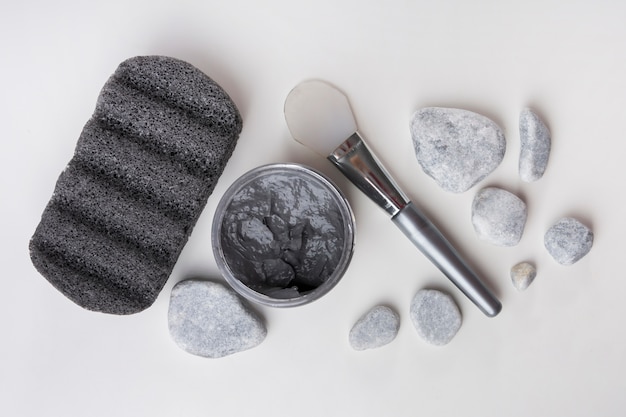 Pumice stone; spa stones; clay mask and brush on white background