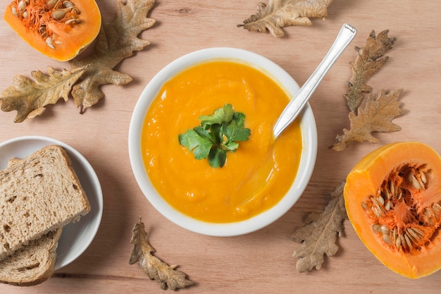 Pumpkin cream soup with bread flat lay