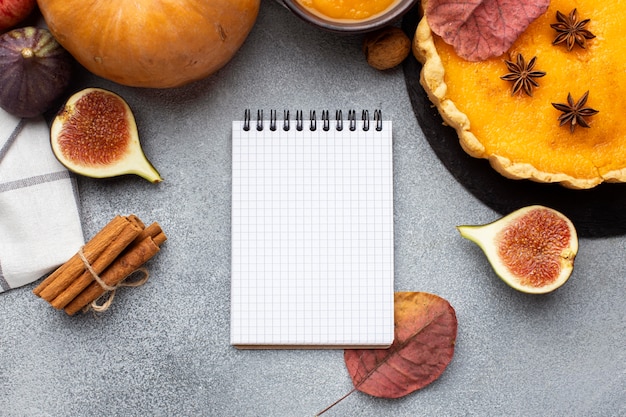 Free photo pumpkin pie and empty notebook