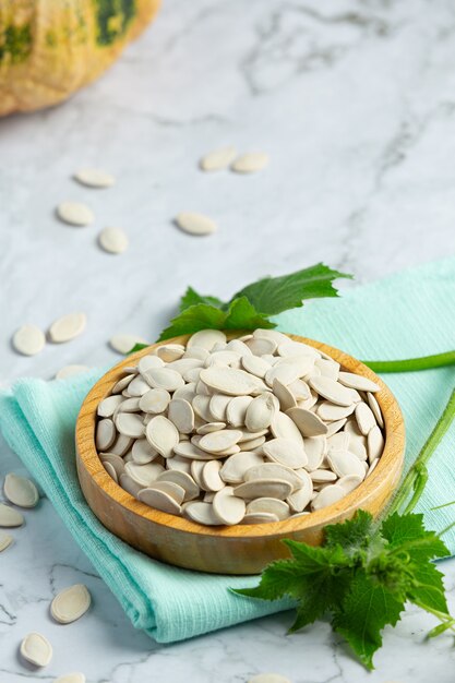 Pumpkin seed put in wooden bowl on white marble floor