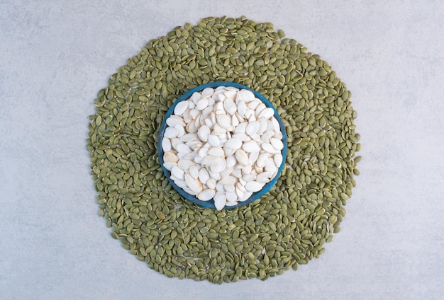 Free photo pumpkin seeds isolated on concrete background.