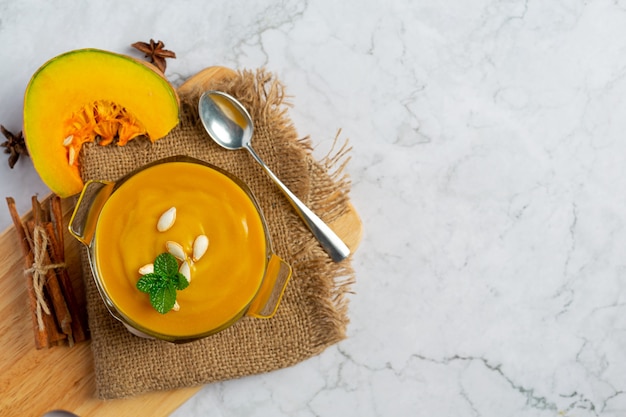 Pumpkin soup in glass bowl place on sack fabric