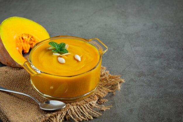 Pumpkin soup in glass bowl place on sack fabric