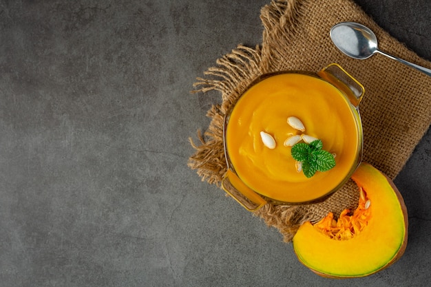 Pumpkin soup in glass bowl place on sack fabric