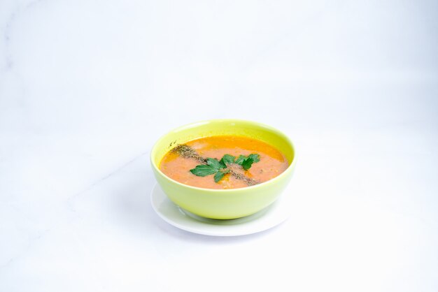 Pumpkin soup topped with pepper and herbs