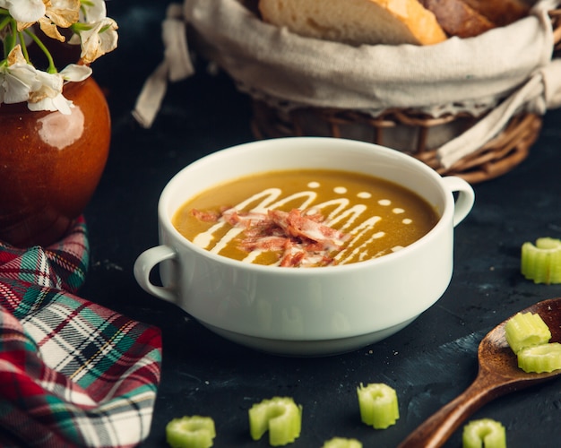 pumpkin soup with grilled chicken pieces garnished with cellery stick slices