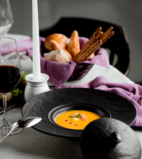 Pumpkin soup with shrimp and a glass of red wine