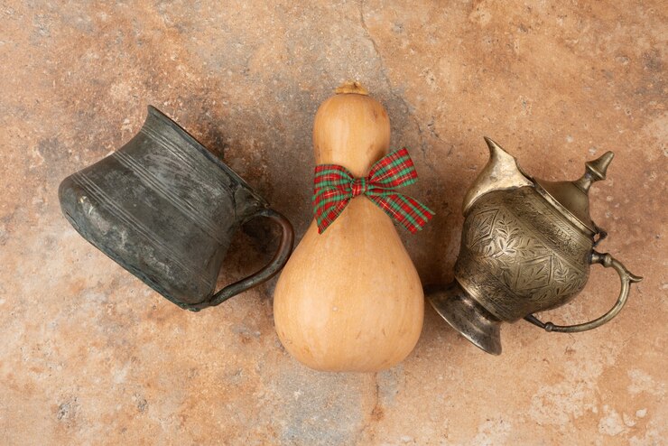 मुफ़्त फोटो pumpkin with bow and ancient kettle on marble.