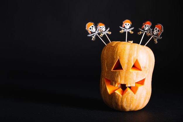 Free photo pumpkin with sticks on black