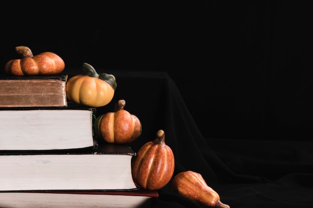 Pumpkins and books on black background