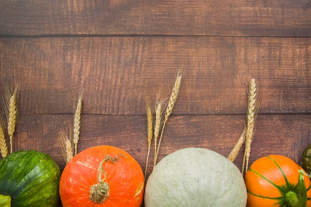 Pumpkins on table with wheat