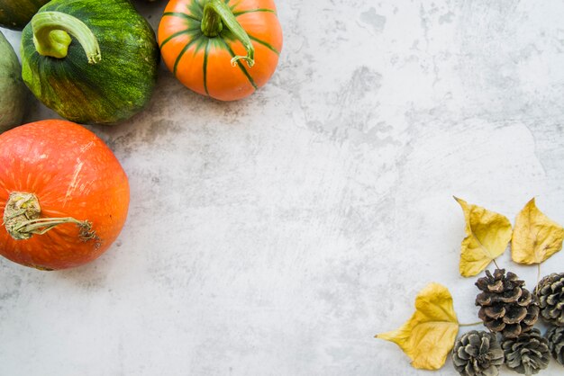 Pumpkins on table with yellow leaflets