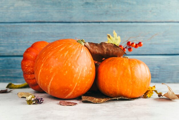 Pumpkins with leaves on table