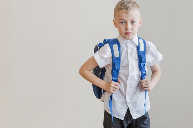 Pupil in backpack standing in studio