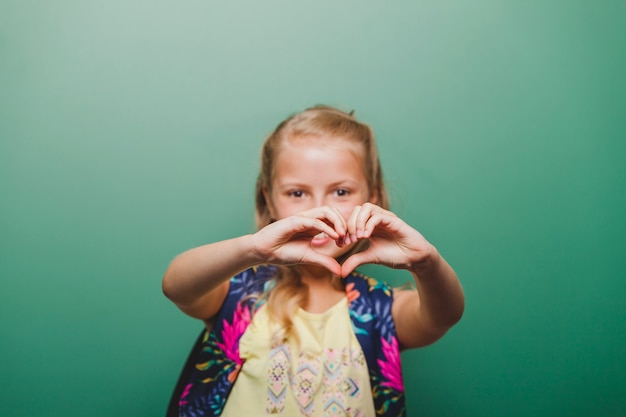 Pupil girl gesturing heart