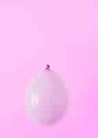 Бесплатное фото Фиолетовый шар на розовом фоне