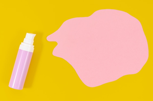 Purple bottle of foundation on pink and yellow background