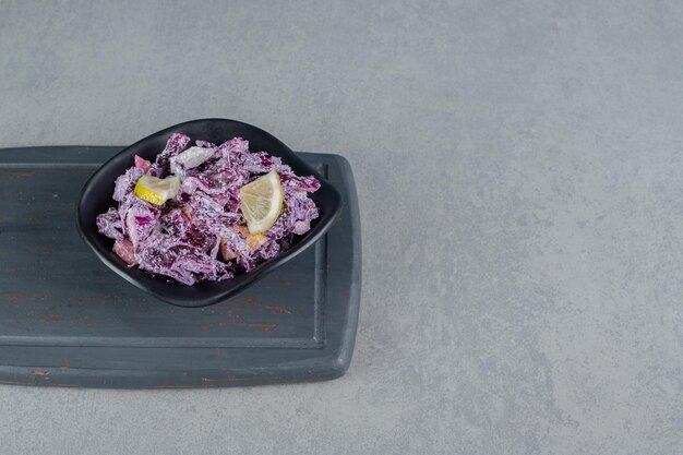 Purple cabbage and onion salad in a ceramic cup.