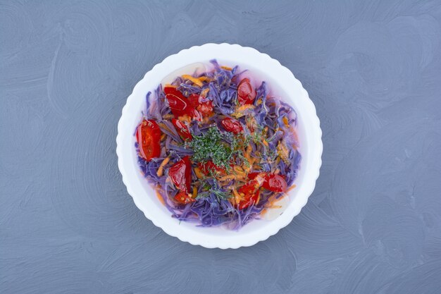 Purple cabbage and red chili sauce in a white bowl