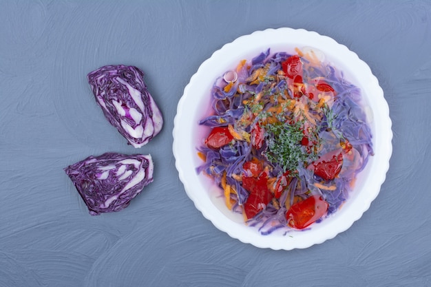 Purple cabbage and red chili sauce in a white bowl