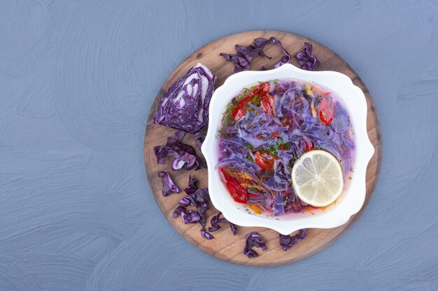 Purple cabbage soup with chili peppers on a wooden board