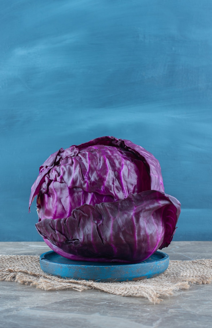 Free Photo purple cabbage on the wooden plate, on the trivet , on the marble table. 