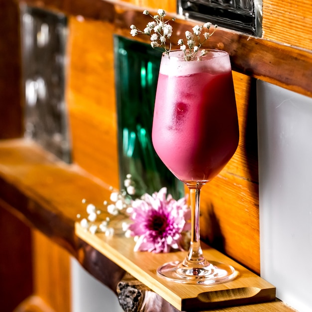 Фиолетовый коктейль, украшенный гипсофилой в длинном стакане