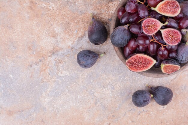 Purple figs and cornel berries in a wooden cup