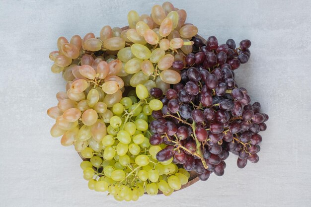 Purple and green grapes on wooden plate. High quality photo