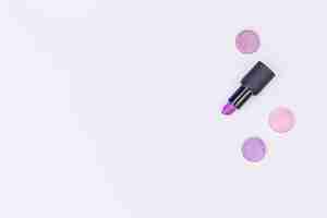 Бесплатное фото Фиолетовая помада и тени для век на белом фоне