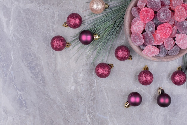 Purple marmelades in a wooden cup with glittering balls around