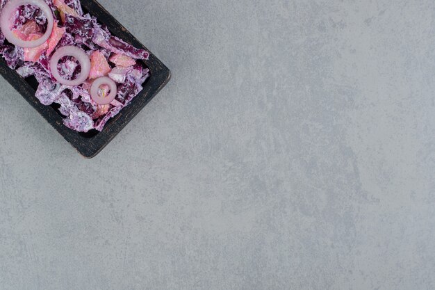 Purple onion salad on a square board