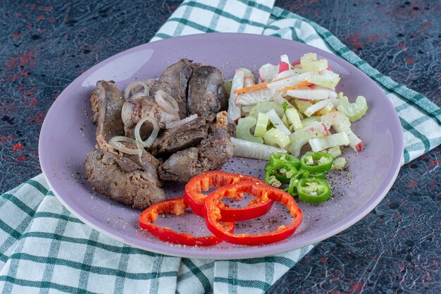 Foto gratuita un piatto viola di carne deliziosa con verdure.