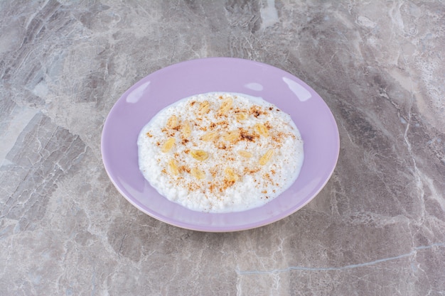 A purple plate full of healthy oatmeal porridge with cinnamon powder