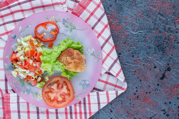 A purple plate of vegetable salad and chicken meat. 