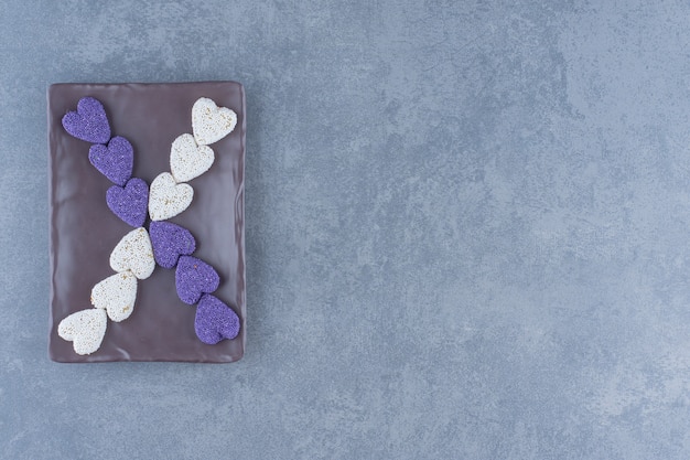 ボード上の紫と白のクッキー、大理石の背景。