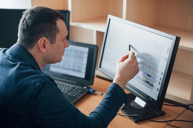 Free photo putting attention for every moment. polygraph examiner works in the office with his lie detector's equipment