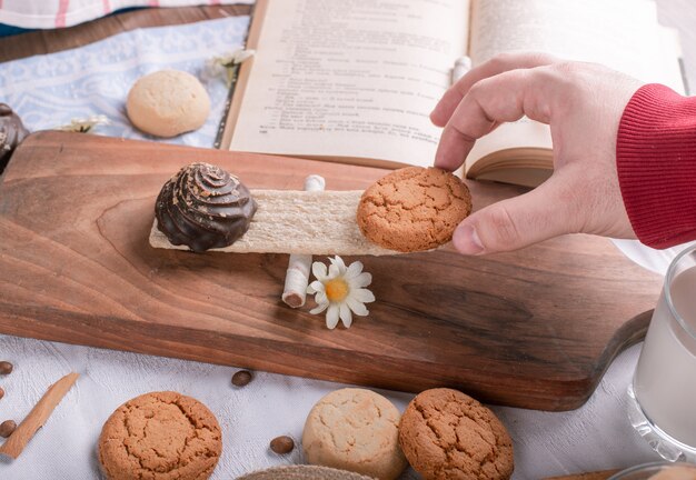 Putting a cookie on a wooden board on a piece of cracker