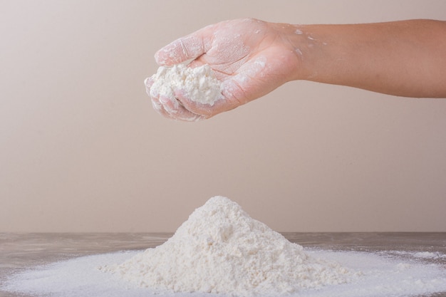 Putting flour on ground for dough making.
