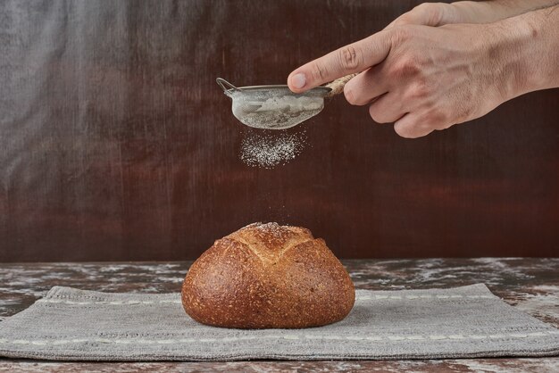 パンのパンの上に小麦粉を置きます。