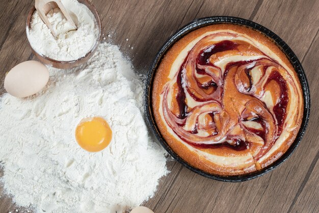 Putting ingredients on a wooden table and making pie