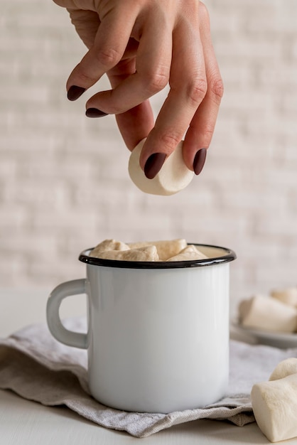 Free photo putting marshmallow in tea