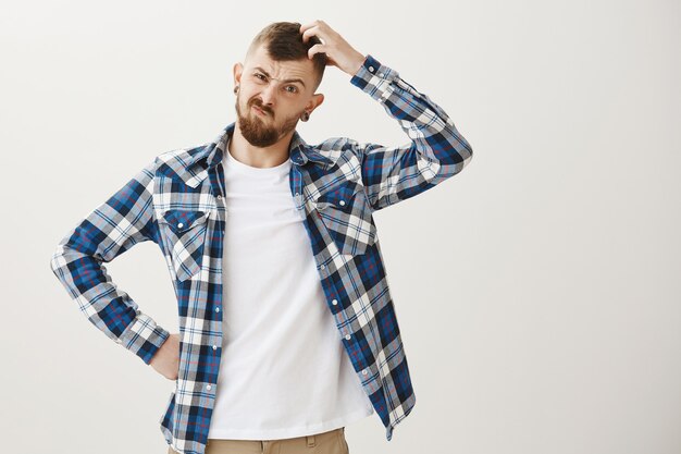 Puzzled guy trying think, scratch head indecisive