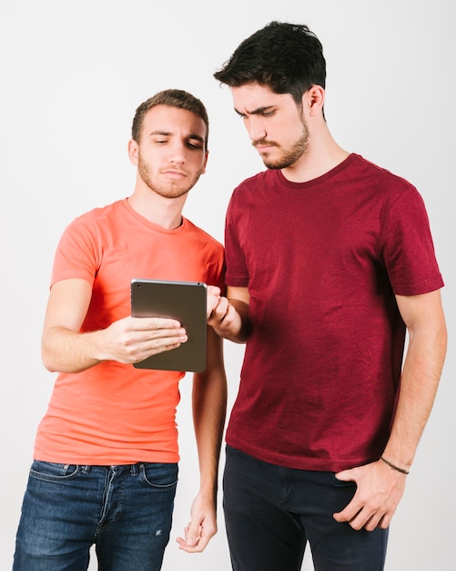 Puzzled modern men using tablet