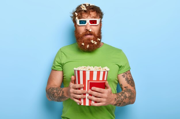 Puzzled red haired man stares at camera through cinema glasses