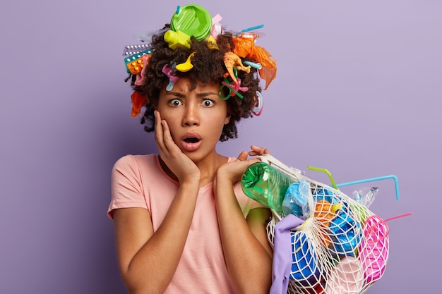 Puzzled stupefied woman posing with garbage in her hair