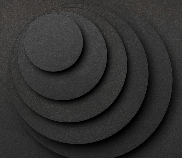 Free photo pyramid of circular pieces of black paper